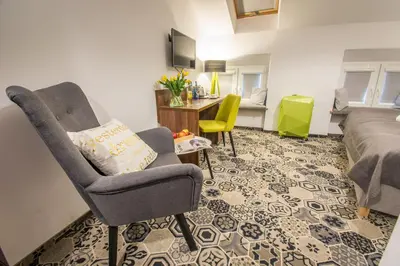 a living room with a chair and a couch at Hotel Lavender in Kraków