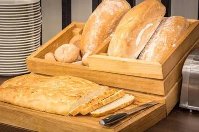 a wooden tray filled with breads and a knife at Hotel Lavender in Kraków