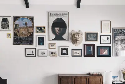 a wall full of pictures on a white wall at Pradnik Valley Lodge in Prądnik Korzkiewski