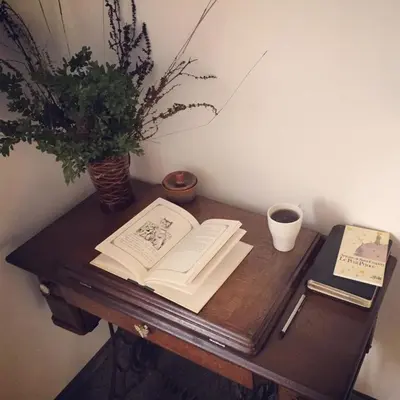 a wooden table with an open book and a potted plant at Pradnik Valley Lodge in Prądnik Korzkiewski