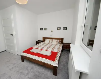 a bedroom with a bed with a red blanket at Pradnik Valley Lodge in Prądnik Korzkiewski