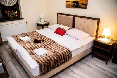a bedroom with a large bed with two towels on it at Hotel Artur in Oświęcim