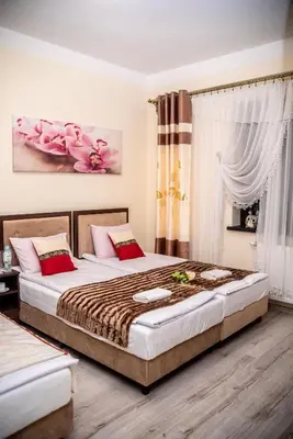 a bedroom with a large bed with red pillows at Hotel Artur in Oświęcim