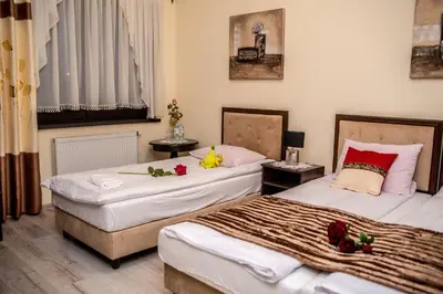 two beds in a hotel room with flowers on them at Hotel Artur in Oświęcim