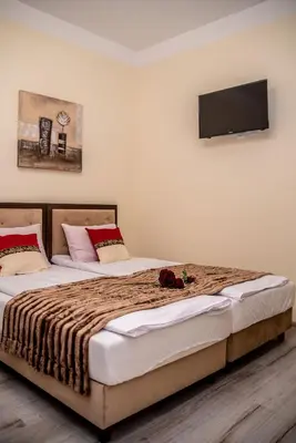 a bedroom with two beds and a television on the wall at Hotel Artur in Oświęcim