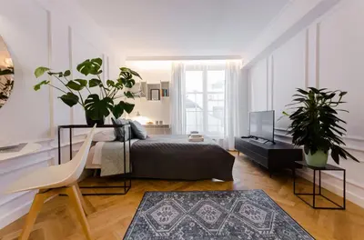 a bedroom with a bed and two potted plants at Old Town Premium Queen`s Apartments in Kraków