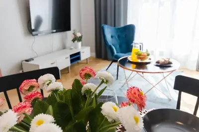 a living room with a table with flowers on it at Old Town Premium Queen`s Apartments in Kraków
