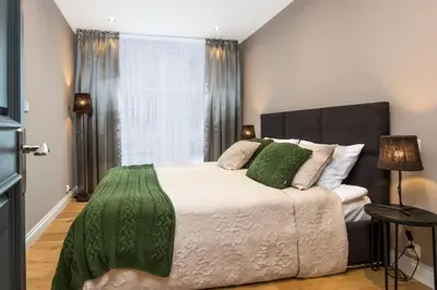 a bedroom with a bed with a green blanket on it at Old Town Premium Queen`s Apartments in Kraków