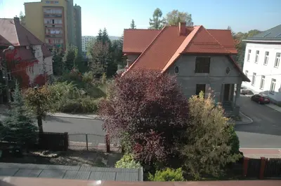 a house with a red roof on a street at Noclegi Jaworzno in Jaworzno