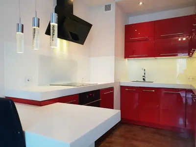 a red and white kitchen with red cabinets at Pawia Apartments Modern in Kraków