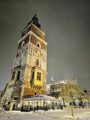 a tall tower with a clock on a building at Pawia Apartments Modern in Kraków