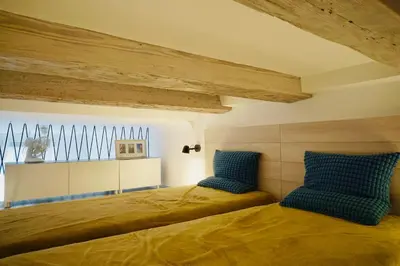 a bedroom with two beds with blue pillows at lux Floriańska in Kraków