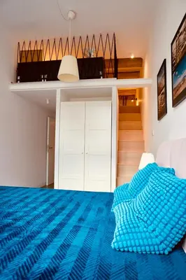 a bedroom with a blue comforter on a bed at lux Floriańska in Kraków