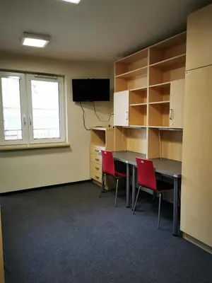 an office room with a desk and two red chairs at Dom Studencki Zaułek in Kraków