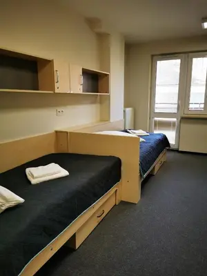 a room with two beds and a window at Dom Studencki Zaułek in Kraków