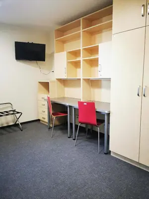 a conference room with a table and chairs and cabinets at Dom Studencki Zaułek in Kraków