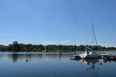 a sailboat is docked at a dock on a lake at Dom Studencki Atol in Kraków