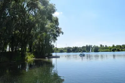 a boat on a lake with trees on the shore at Dom Studencki Atol in Kraków