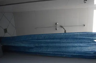 a blue bath tub in a room with a shower at Dom Studencki Atol in Kraków