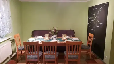 a dining room with a table and four chairs at Guzikowa Chata in Dobczyce