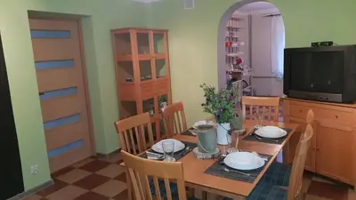 a dining room with a table and a television at Guzikowa Chata in Dobczyce