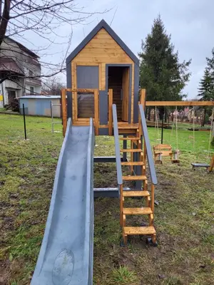 a playground with a slide and a play house at Guzikowa Chata in Dobczyce