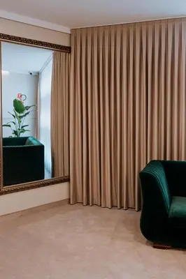 a living room with a mirror and a green chair at Mark1 in Brzesko