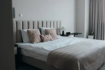 a bedroom with a large bed with white sheets and pillows at Mark1 in Brzesko