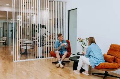 a man and a woman sitting in chairs in a room at Mark1 in Brzesko