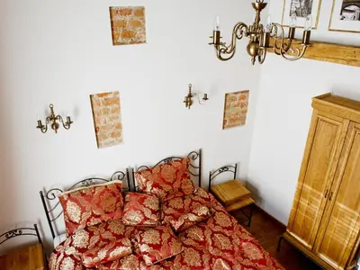 a bedroom with a bed and a chandelier at Pokoje Leonardo in Kraków