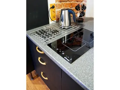 a kitchen with a stove top oven next to a counter at Pokoje Leonardo in Kraków