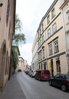 a city street with parked cars and buildings at Pokoje Leonardo in Kraków