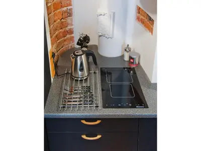 a kitchen counter with a sink and a tea kettle at Pokoje Leonardo in Kraków
