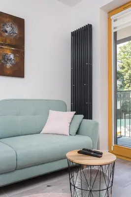 a living room with a green couch and a table at City of the Kings - Pastel Apartment Lubelska 10 in Kraków