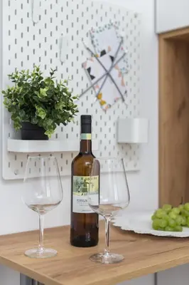a bottle of wine and two wine glasses on a table at City of the Kings - Pastel Apartment Lubelska 10 in Kraków