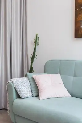 a blue couch with a pink pillow on it at City of the Kings - Pastel Apartment Lubelska 10 in Kraków