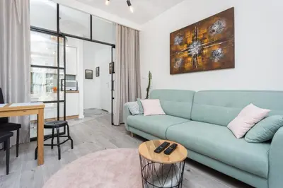 a living room with a blue couch and a table at City of the Kings - Pastel Apartment Lubelska 10 in Kraków