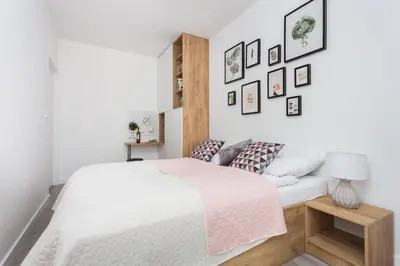 a white bedroom with a bed and a lamp at City of the Kings - Pastel Apartment Lubelska 10 in Kraków