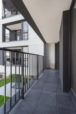 an empty balcony of a building with black railing at City of the Kings - Pastel Apartment Lubelska 10 in Kraków