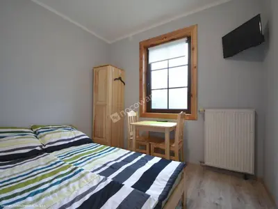 a bedroom with a bed and a table and a window at Dom Wypoczynkowy przy Szlaku OJCÓW in Ojców