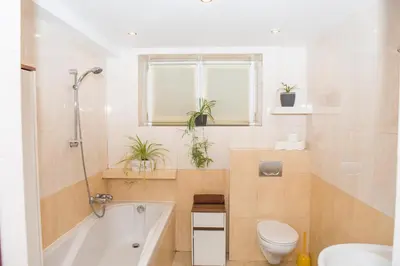 a bathroom with a tub and a toilet and a sink at Parkowa House in Kraków