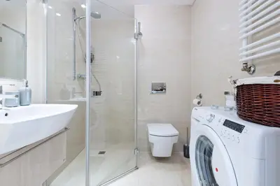 a bathroom with a washing machine and a sink at Kopernika8 Miro Apartment with Balcony and AC in Kraków