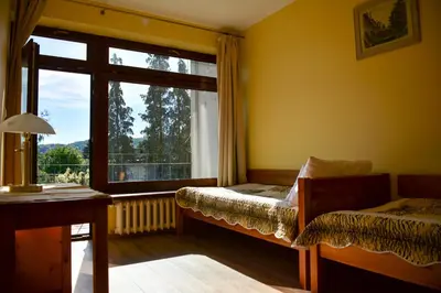 a bedroom with a window and a bed and a desk at Apartamenty Argo in Kraków
