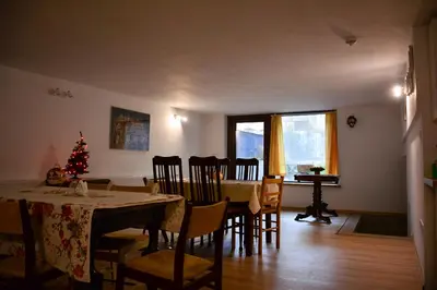 a dining room with a table and chairs and a christmas tree at Apartamenty Argo in Kraków