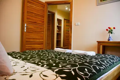 a bedroom with a bed with a black and white blanket at Apartamenty Argo in Kraków