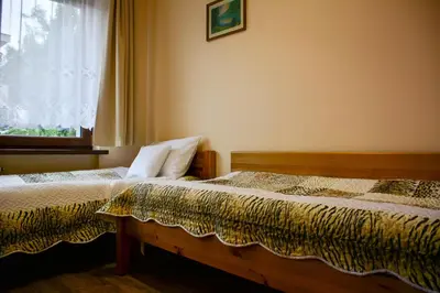 two beds in a bedroom with a window at Apartamenty Argo in Kraków