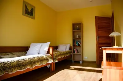 a yellow room with a bed and a book shelf at Apartamenty Argo in Kraków