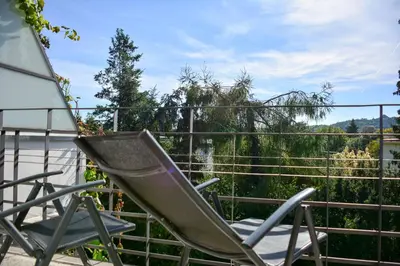a pair of chairs sitting on a balcony at Apartamenty Argo in Kraków