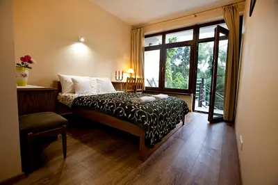 a bedroom with a bed and a large window at Apartamenty Argo in Kraków