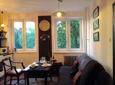 a living room with a couch and a table and windows at Absolutely Apartment in Kraków
